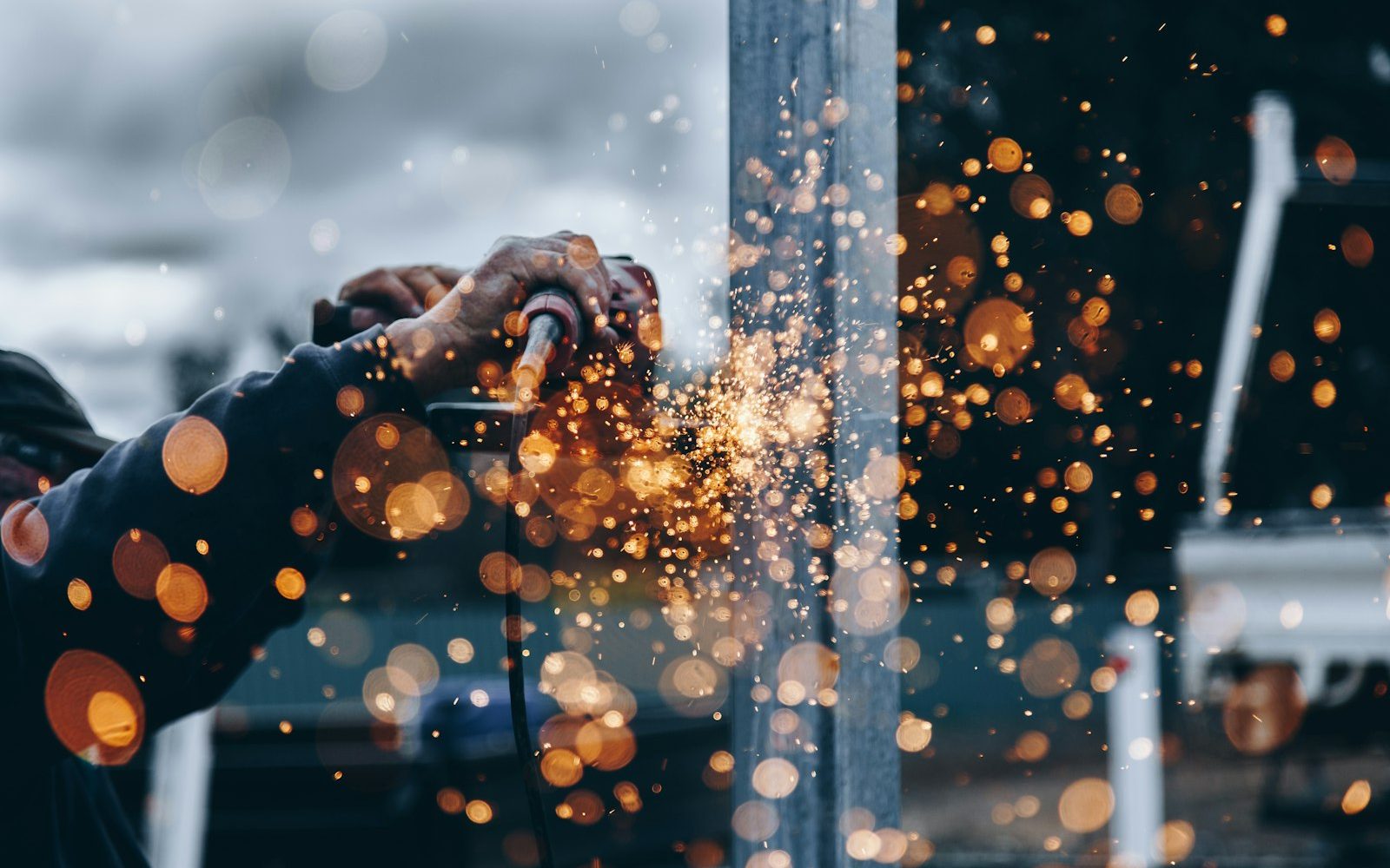 Worker operating an angle grinder with sparks flying during an industrial hazard assessment